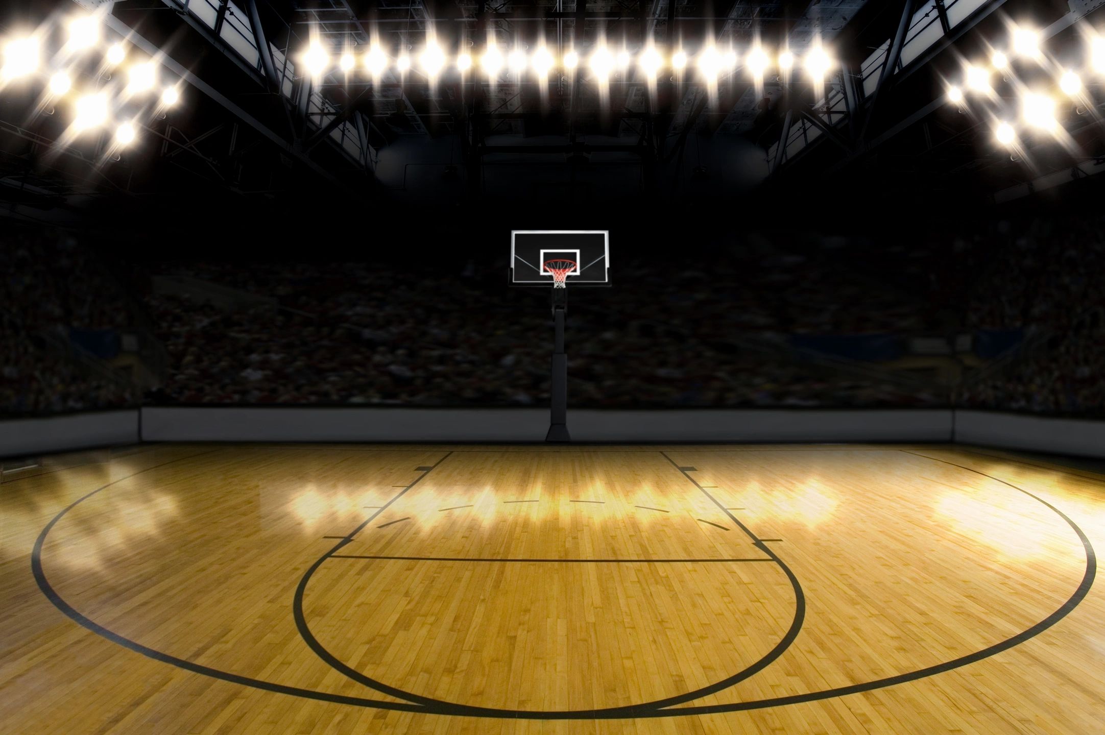 An empty basketball stadium with lights on